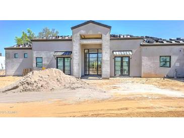 A modern home's front exterior features a stylish entry and an unfinished roof at 6426 E Turquoise Ave, Paradise Valley, AZ 85253