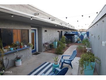 Cozy backyard patio featuring string lights, garden, and blue accent furniture at 8848 N New World Dr, Glendale, AZ 85302