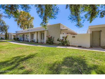 Inviting single-story home featuring desert landscaping, shade trees, and a private gated entrance in a well-maintained community at 8848 N New World Dr, Glendale, AZ 85302