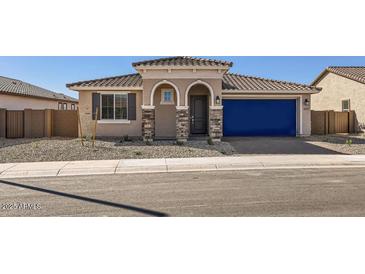 Charming single-story home featuring a tiled roof, blue garage door, and landscaped front yard at 25347 N 176Th Ave, Surprise, AZ 85387