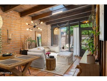 Bright living room features brick walls, terracotta tile flooring, and contemporary lighting fixtures at 3032 N 32Nd St # 61, Phoenix, AZ 85018
