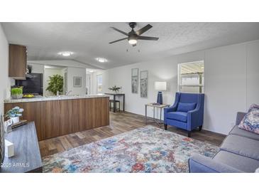 Bright living room with wood floors, neutral walls, stylish furnishings, and modern ceiling fan at 320 E Mckellips Rd # 25, Mesa, AZ 85201