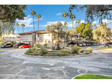 A well maintained community fountain surrounded by beautiful trees, plants and covered parking spaces at 7557 N Dreamy Draw Dr # 154, Phoenix, AZ 85020