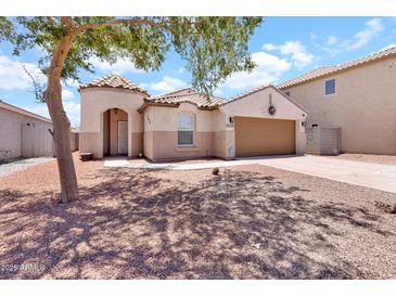 Charming single-story home featuring a low-maintenance desert landscape and a two-car garage at 1623 E Maplewood Ave, Buckeye, AZ 85326
