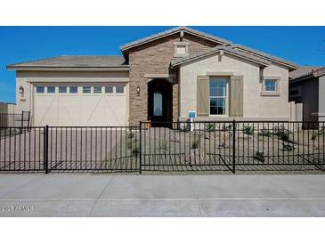 Charming single-story home with stone accents, desert landscaping, and secure black metal fence at 16342 W Jackson St, Goodyear, AZ 85338