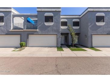 Contemporary townhome with private garage and balcony with modern gray stucco and a well-manicured landscape at 1851 W Vermont Ave, Phoenix, AZ 85015