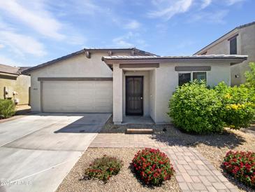 Charming single-story home featuring a two-car garage, covered entry, and meticulously landscaped front yard at 1953 W Stage Driver St, Apache Junction, AZ 85120