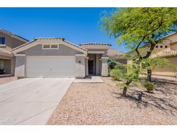 Charming single-story home featuring a desert landscape, an attached two-car garage, and a welcoming entryway at 23852 W La Salle St, Buckeye, AZ 85326