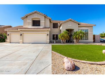 Charming two-story home featuring a three-car garage and well-manicured front yard with palm trees at 4530 E Decatur St, Mesa, AZ 85205