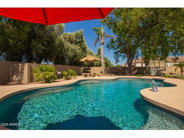 Backyard pool featuring a baja shelf, a tanning ledge, ample seating, and privacy landscaping at 5534 W Riviera Dr, Glendale, AZ 85304