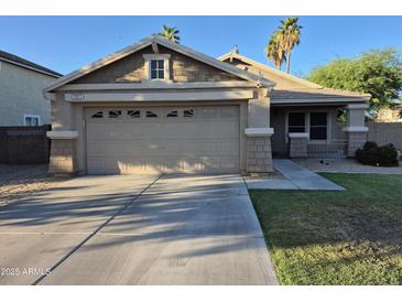 Charming single-Gathering home featuring a two-car garage and well-maintained front yard in a desert landscape at 7027 W Midway Ave, Glendale, AZ 85303