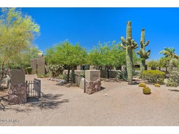 Expansive front yard featuring native desert landscaping and a gated entrance to the property at 8306 E Buckskin Trl, Scottsdale, AZ 85255