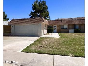 Charming single-story home featuring a well-maintained front lawn, attached garage, and welcoming entrance with desert landscaping at 10727 W Kelso Dr, Sun City, AZ 85351