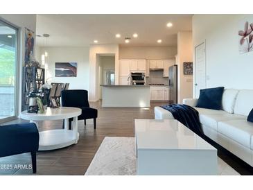 Bright living room with an open layout, white furniture, and modern finishes, adjacent to kitchen at 20952 E Via Del Sol --, Queen Creek, AZ 85142