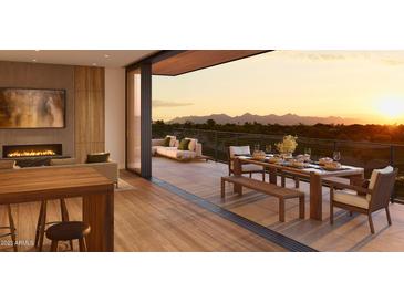 Beautiful balcony view with mountain backdrop, dining area, and lounge area with a fireplace at 4849 N Camelback Ridge Rd # B308, Scottsdale, AZ 85251