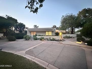 Charming single-story home features a desert landscape, warm exterior lighting, and inviting curb appeal at 4856 E Cheryl Dr, Paradise Valley, AZ 85253