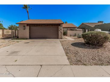 Charming single-story home featuring a brick facade, a two-car garage, and low-maintenance landscaping at 5101 W Purdue Ave, Glendale, AZ 85302