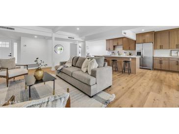 Open floor plan showcasing a modern living room seamlessly connected to a kitchen with stainless steel appliances at 6233 E Pinchot Ave, Scottsdale, AZ 85251