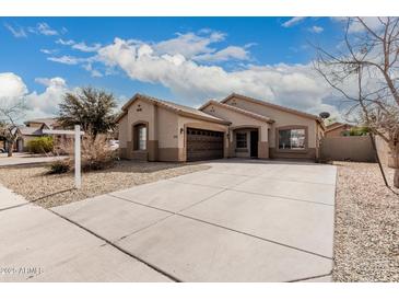 Charming single-story home showcasing a neutral color palette, a spacious driveway, and a two-car garage at 9325 W Elwood St, Tolleson, AZ 85353