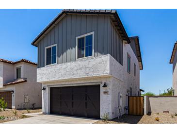 Charming two-story home featuring grey siding, a stucco base, dark garage door, and well-manicured landscaping at 9408 E Sequence Ave, Mesa, AZ 85212