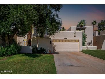 Inviting two-story home with a well-manicured lawn, mature shade tree and spacious two car garage at 1036 N Sierra Hermosa Dr, Litchfield Park, AZ 85340