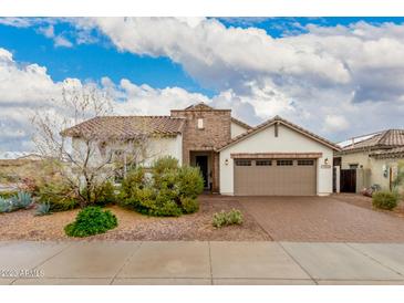 Charming single-story home with a well-manicured front yard and a two-car garage at 17909 W Agave Rd, Goodyear, AZ 85338