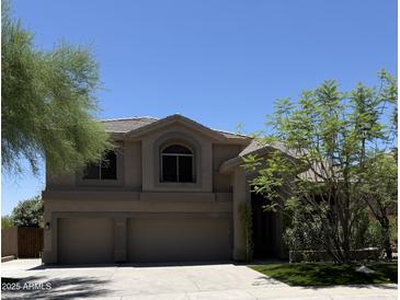 Charming two-story home with a three-car garage and desert landscaping is bathed in sunshine at 33220 N 60Th Way, Scottsdale, AZ 85266