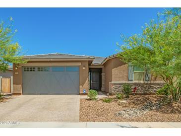 Charming single-story home featuring a two-car garage and drought-resistant landscaping at 17352 W Red Fox Rd, Surprise, AZ 85387
