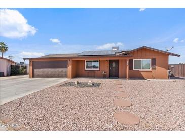 Charming single-story home featuring a two-car garage, desert landscaping, and a welcoming front porch at 2319 N 71St Dr, Phoenix, AZ 85035