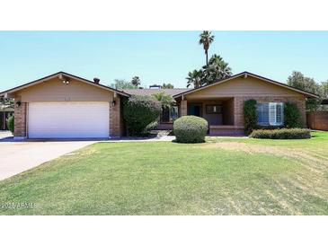 Charming single-story home featuring a well-manicured lawn and a classic brick exterior at 3033 W Tierra Buena Ln, Phoenix, AZ 85053