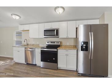 Well-lit kitchen featuring stainless steel appliances, bright white cabinetry, and laminate countertops at 320 E Mckellips Rd # 245, Mesa, AZ 85201