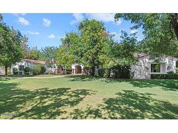 Expansive front yard of Spanish-style home featuring a lush lawn and mature trees, creating a serene and inviting atmosphere at 5225 N 23Rd St, Phoenix, AZ 85016