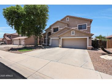 A two-story home with a three-car garage, landscaped front yard, and neutral colored paint at 5744 E Jacaranda St, Mesa, AZ 85205