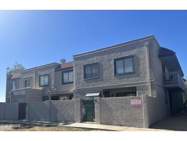 A well-maintained two-story townhome featuring a stucco exterior and a red tile roof at 2311 E Hartford Ave # 38, Phoenix, AZ 85022