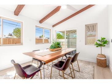 Bright dining room featuring wood table, modern chairs, and ample natural light at 3118 W Windrose Dr, Phoenix, AZ 85029