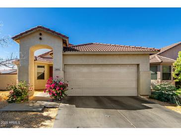 Charming single-story home with a tile roof, two-car garage, and well-maintained landscaping at 5654 W Vineyard Rd, Laveen, AZ 85339