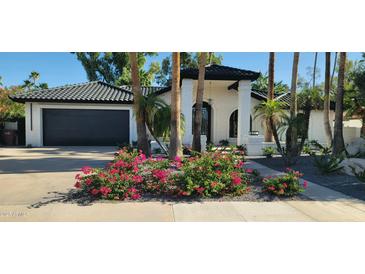 Charming one-story home featuring white brick, dark tile roof, and beautiful Bougainvillea landscaping at 7724 E Charter Oak Rd, Scottsdale, AZ 85260