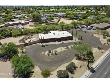 Aerial view of a single-story home with a modern style, circular driveway, desert landscaping, and a fenced pool at 11041 N Hayden Rd, Scottsdale, AZ 85260