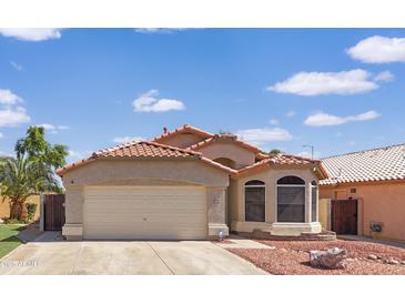 Charming single-story home with a red-tiled roof, neutral stucco and a well-maintained front yard at 12770 W Alvarado Rd, Avondale, AZ 85392