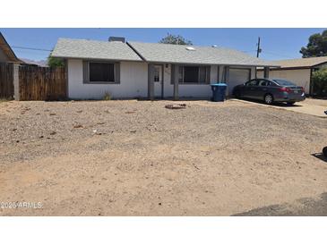 Modest single-story home with low maintenance landscaping, attached garage, and a neutral exterior paint at 1843 S Papago Dr, Apache Junction, AZ 85120