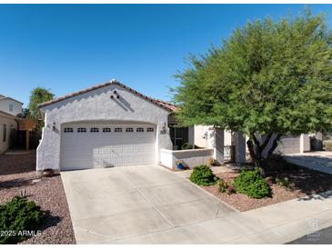 Charming single-story home featuring a two-car garage, desert landscaping, and a well-maintained front yard at 26243 W Wahalla Ln, Buckeye, AZ 85396