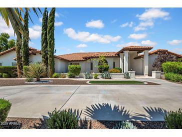 Stunning home featuring a beautifully landscaped front yard with circular driveway and desert landscaping at 5320 W Soft Wind Dr, Glendale, AZ 85310