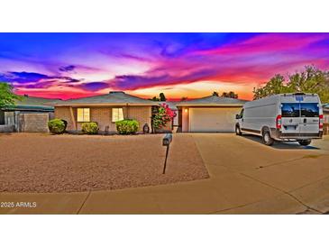 Charming single-story home featuring a brick exterior, desert landscaping, and a two-car garage during a lovely sunset at 3450 W Kaler Dr, Phoenix, AZ 85051