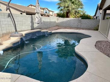 Relaxing backyard pool with waterfall feature, perfect for enjoying sunny days at 8820 W Glenn Dr, Glendale, AZ 85305
