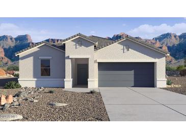 Charming single-story home with a two-car garage, neutral stucco exterior, and desert landscaping at 9343 S Mineros Dr, Apache Junction, AZ 85120