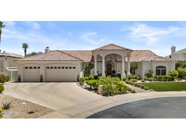 Stunning single-story home with a tile roof, lush landscaping, and a three-car garage on a sunny day at 11439 E Bella Vista St, Scottsdale, AZ 85259