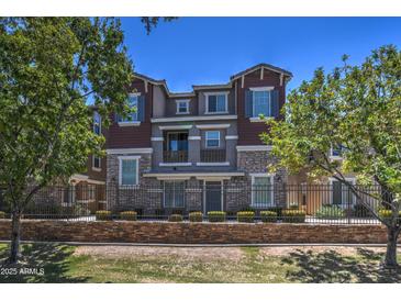 Charming multi-story townhouse featuring stone accents, multiple windows, and mature landscaping at 134 W Campbell Ct, Gilbert, AZ 85233