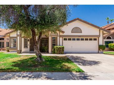 Charming single-story home with a well-maintained lawn and a two-car garage at 2137 E New Bedford Dr, Gilbert, AZ 85234