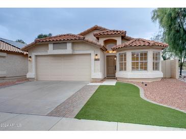 Charming single-story home featuring a red tile roof and a well-manicured lawn at 2203 E Crest Ln, Phoenix, AZ 85024
