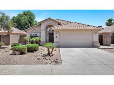 Charming single-story home with a well-manicured front yard, desert landscaping, and a two-car garage at 625 W Douglas Ave, Gilbert, AZ 85233